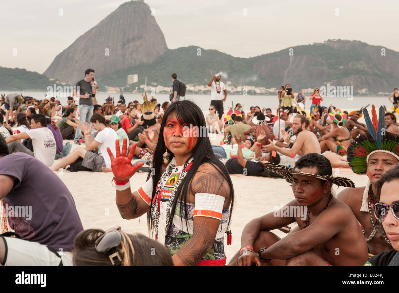 The People's Summit at the United Nations Conference on Sustainable Development (Rio+20), Rio de Janeiro, Brazil. Mayalu Txukaramae Kayapo shows a red painted hand against the building of dams in the Amazon, during the Human Banner demonstration on the beach with the sugar loaf mountain behind. 19th June 2012. Photo © Sue Cunningham. Stock Photo