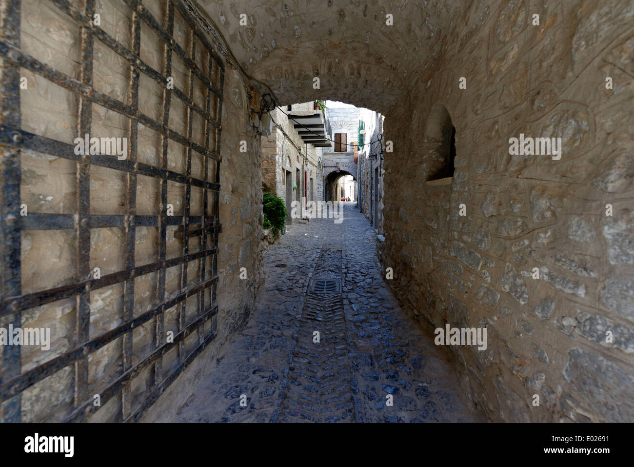 Vaulted arched narrow cobblestone lane with iron gate Medieval town
