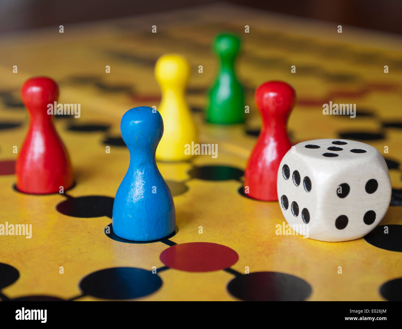 Close up of colorful wooden pins and dices on a classic board game Stock Photo