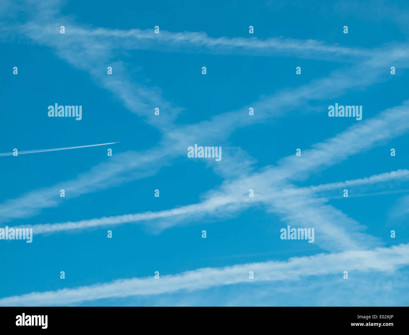 Pattern of many contrails/vapor trails of jet airplanes in the blue sky. Stock Photo