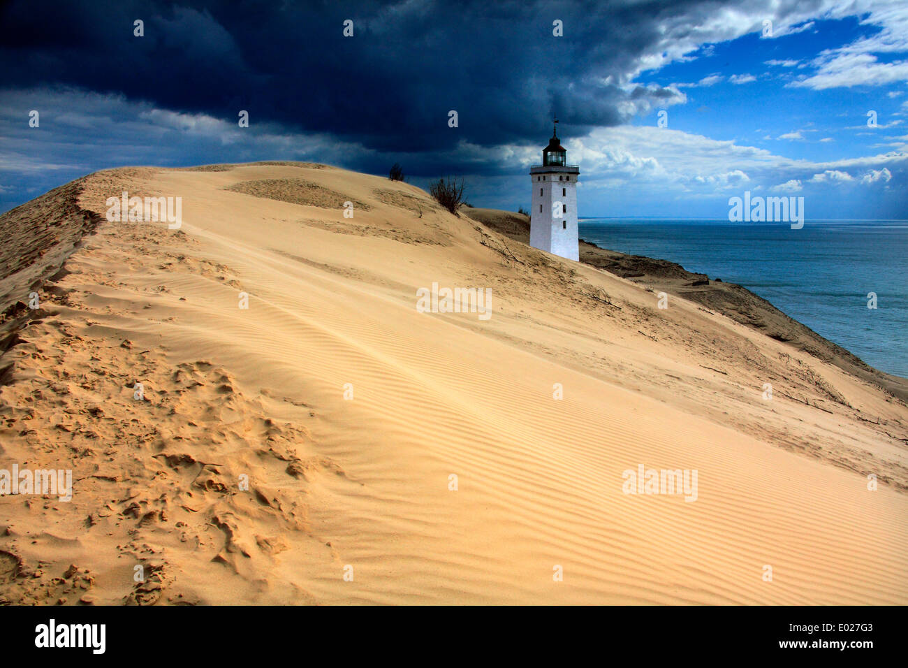 Photo of Rubjerg Knude lighthouse on the coast of North Sea with storm sky Stock Photo