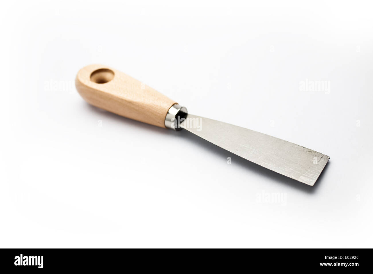 Putty knife with wooden handle on natural light background and a soft
