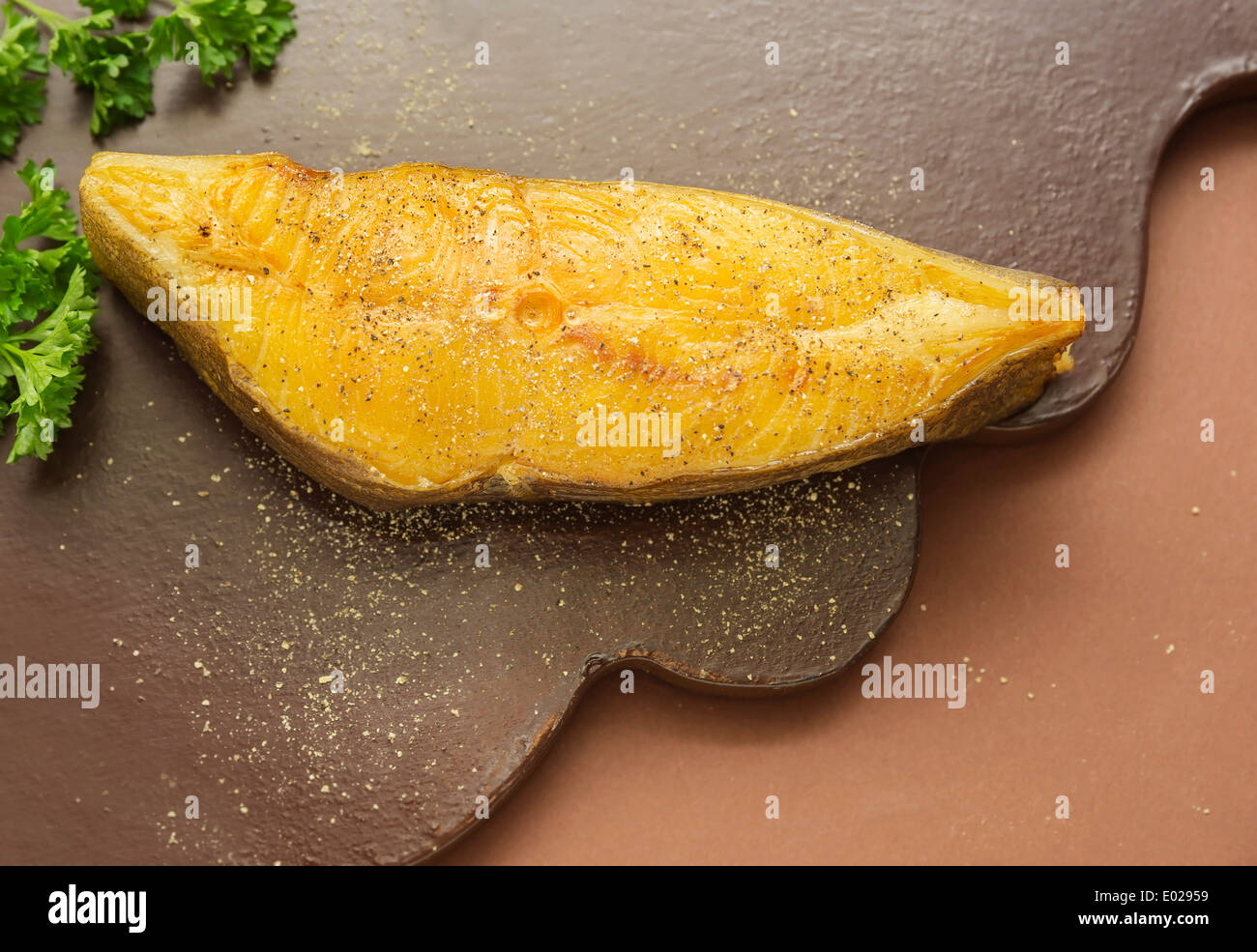 piece of smoked halibut on brown rustic board Stock Photo