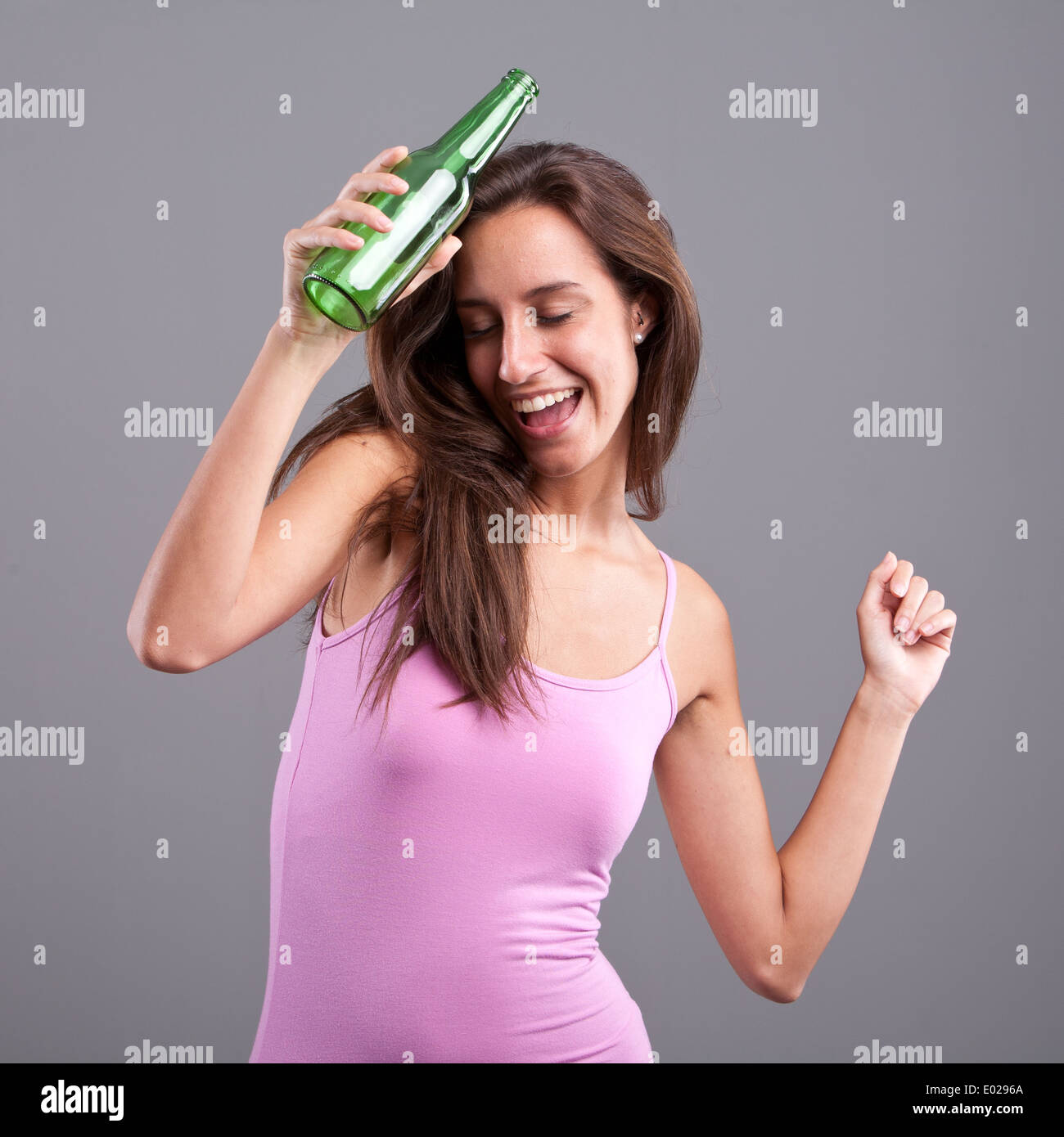 Happy girl dancing or staggering with a green bottle of beer Stock ...