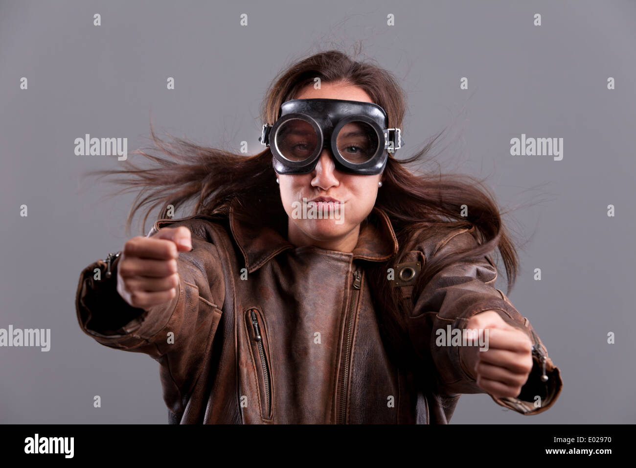 Funny girl with motorbiker big glasses and a leather jacket pretending to blow Stock Photo