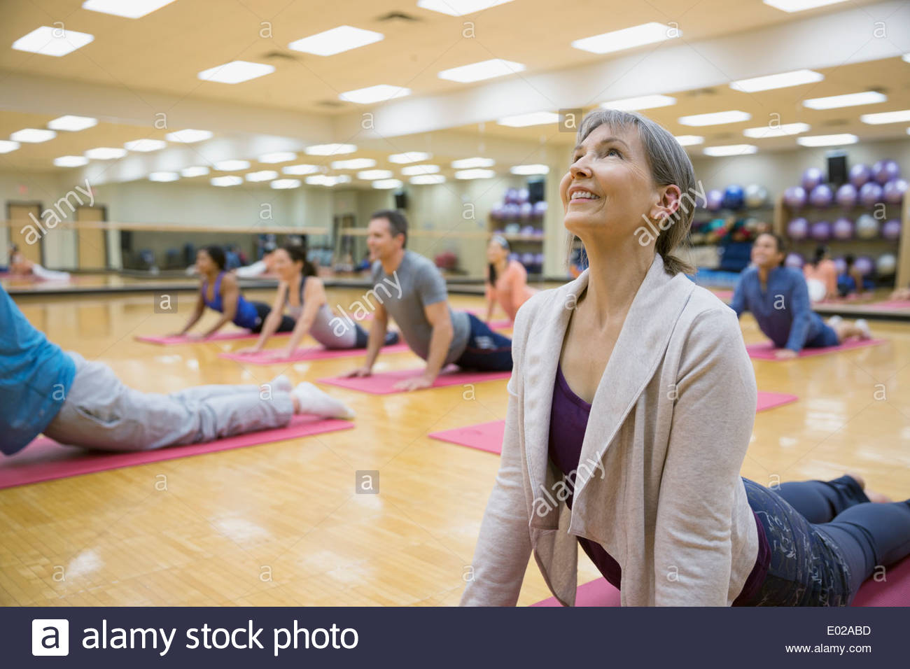 Group practicing upward facing dog in yoga class Stock Photo