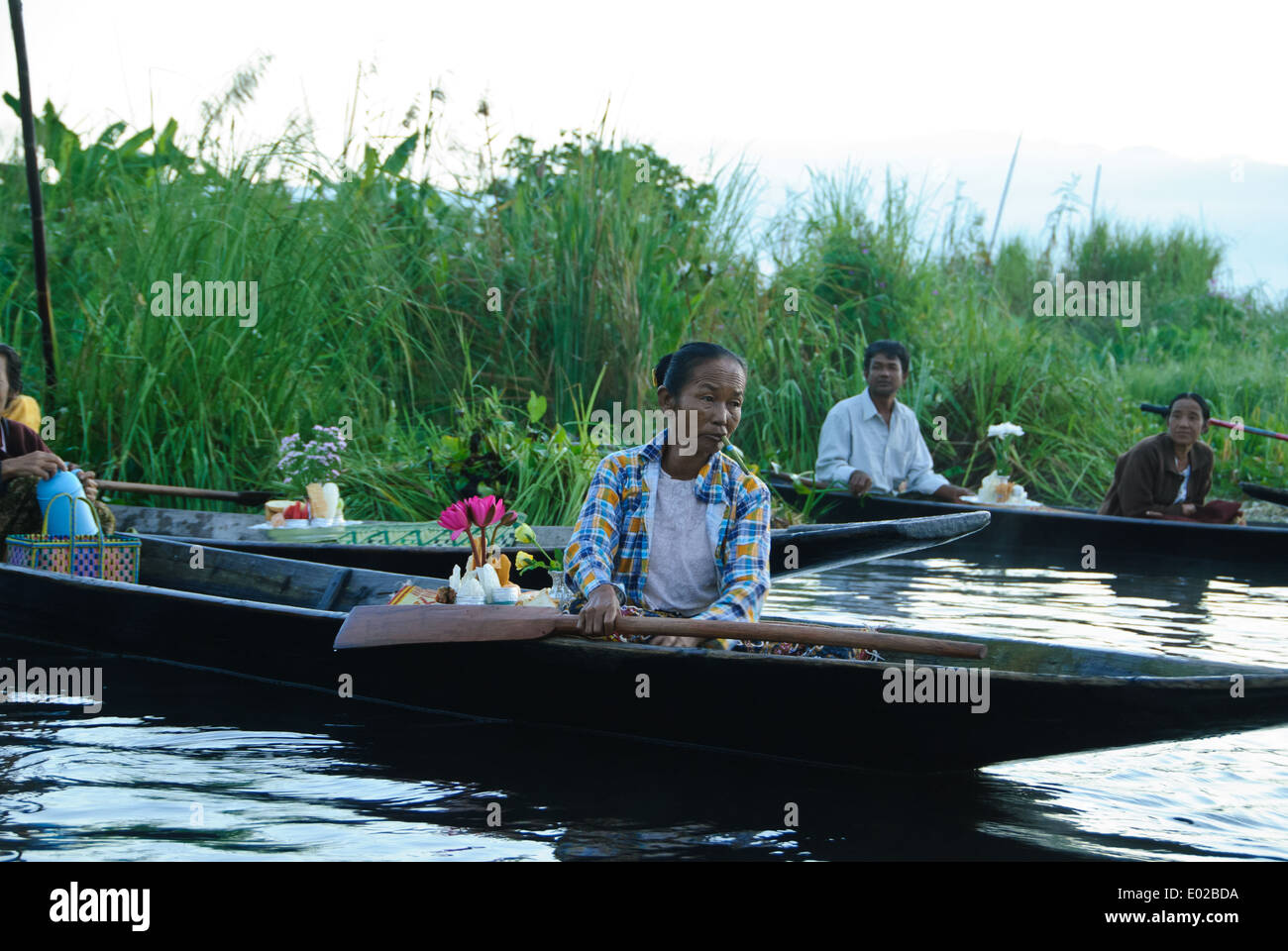Villagers rowing their boats out to wait for the procession Stock Photo