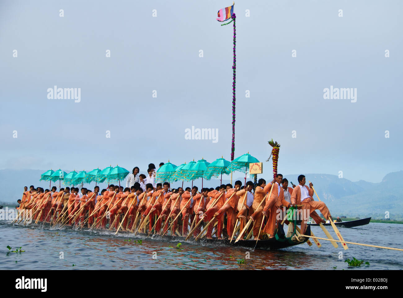 Leg-rowers moving forwards pulling the royal barge across Inle Lake during the festival Stock Photo