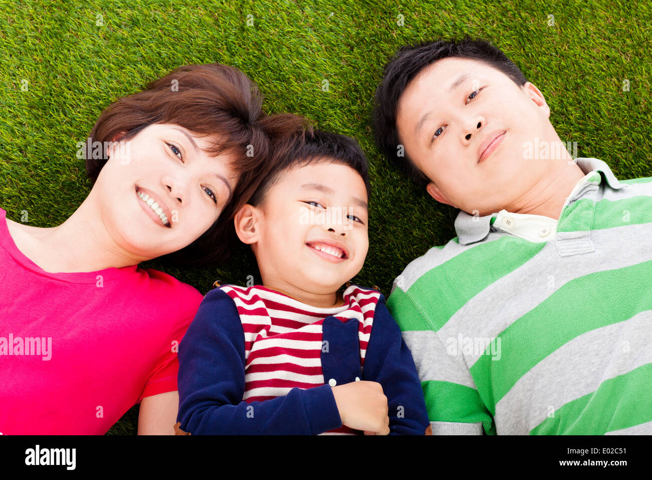 happy parents and son lying on a meadow Stock Photo