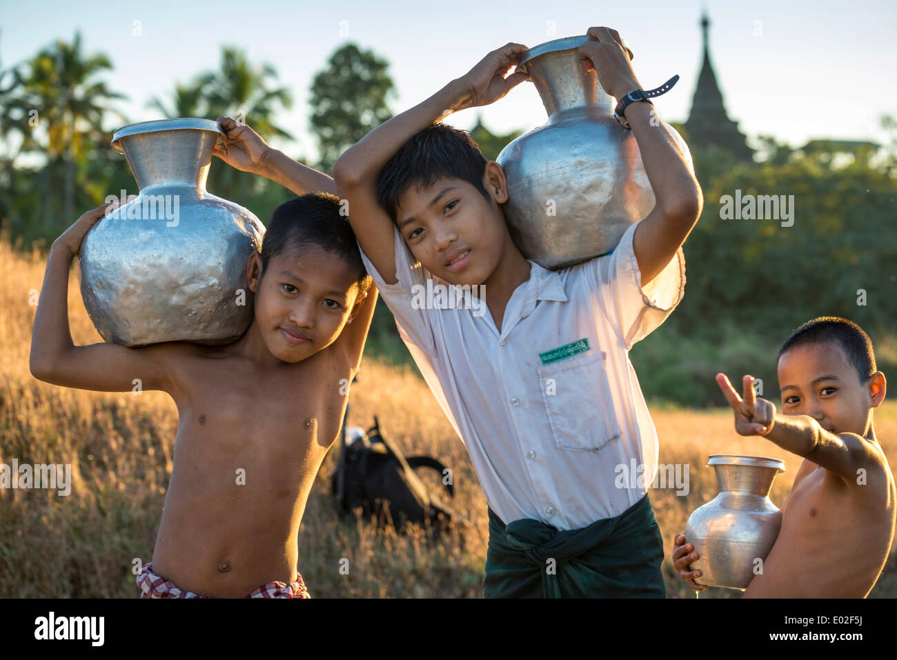 Boys carrying water in water containers made of aluminium, Mrauk U, Sittwe District, Rakhine State, Myanmar Stock Photo