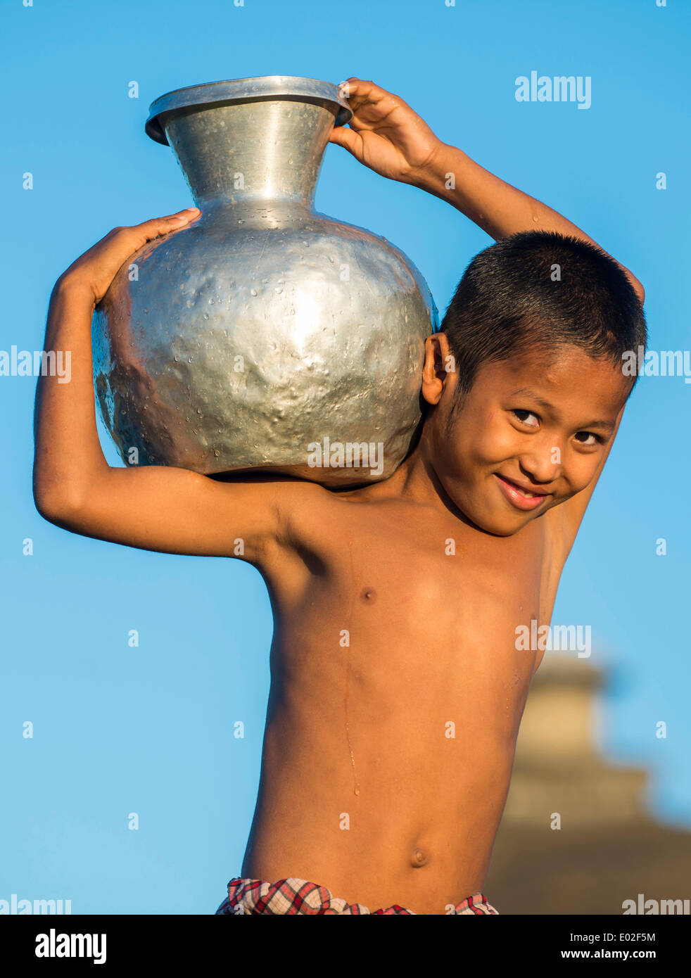 https://c8.alamy.com/comp/E02F5M/smiling-boy-carrying-water-in-a-water-container-made-of-aluminium-E02F5M.jpg