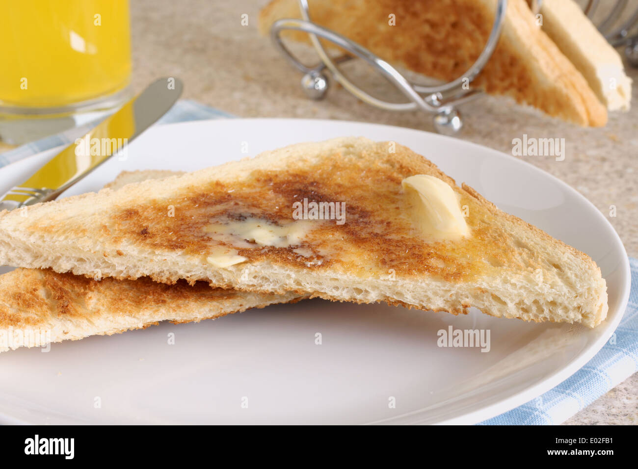 https://c8.alamy.com/comp/E02FB1/white-bread-toast-with-melting-butter-orange-juice-and-a-toast-rack-E02FB1.jpg