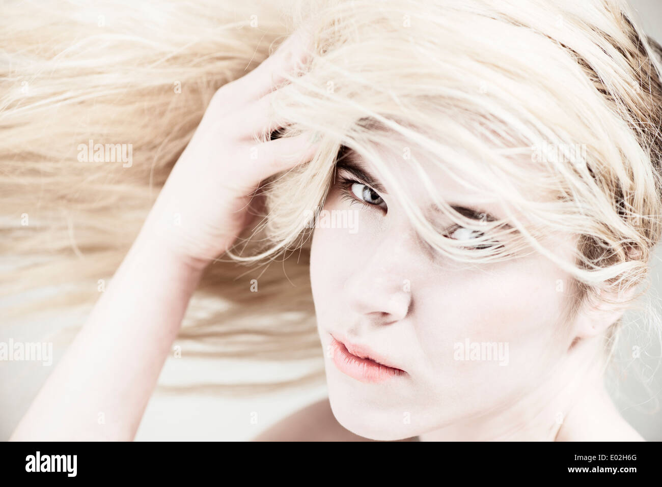 Young beautiful blonde woman with long hair. Showing expression of cool attitude and personality. Stock Photo
