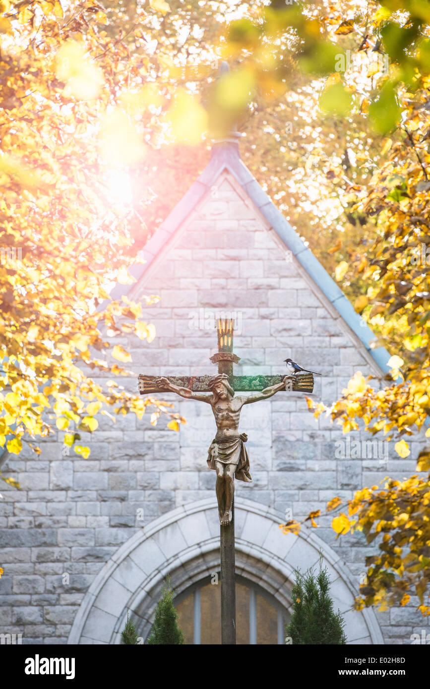 Jesus Christ on the cross in front of old church. Cemetery in Stockholm, Sweden. Stock Photo