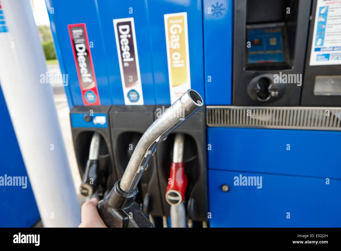 man holding refueling nozzle at gas oil diesel and high speed biofuel diesel pumps at a petrol station northern ireland Stock Photo