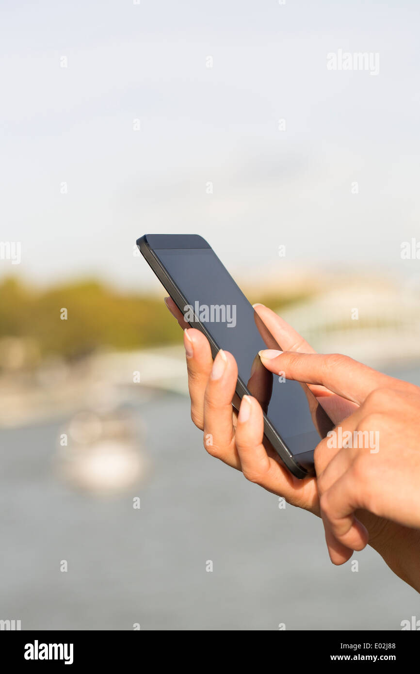 Female Close up of hands mobile phone houseboat seine bridge message sms e-mail Stock Photo