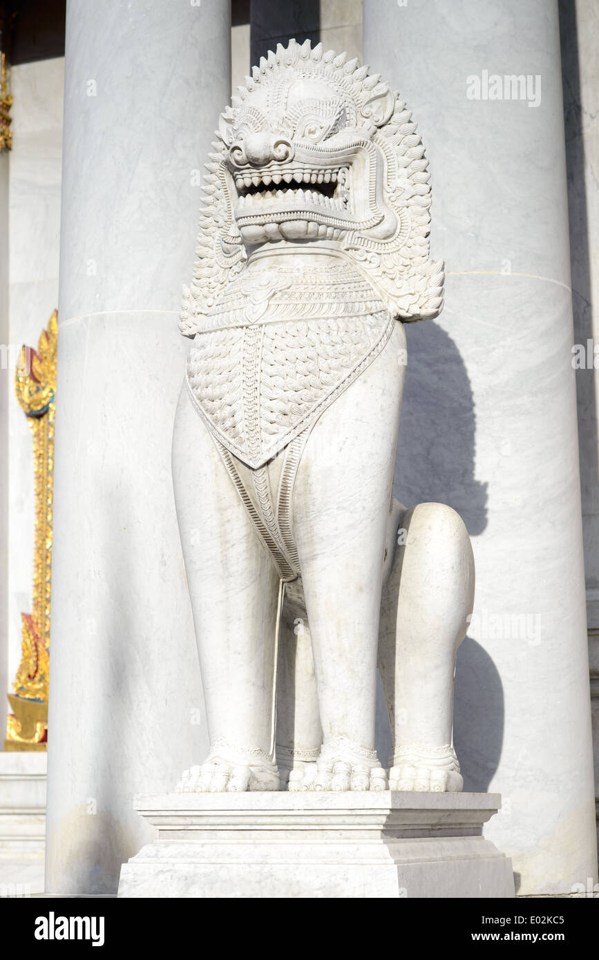 A large white Thai lion sculpture statue, a gate keeper at a Thai temple in Bangkok. Stock Photo