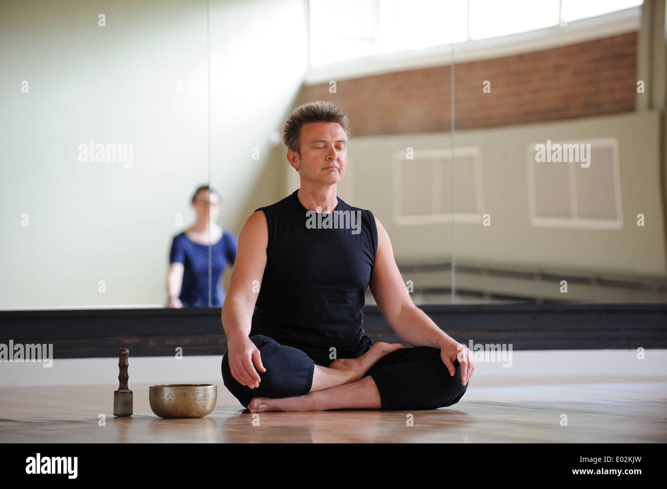 A yoga teacher and class meditating at a Birmingham arts centre Stock