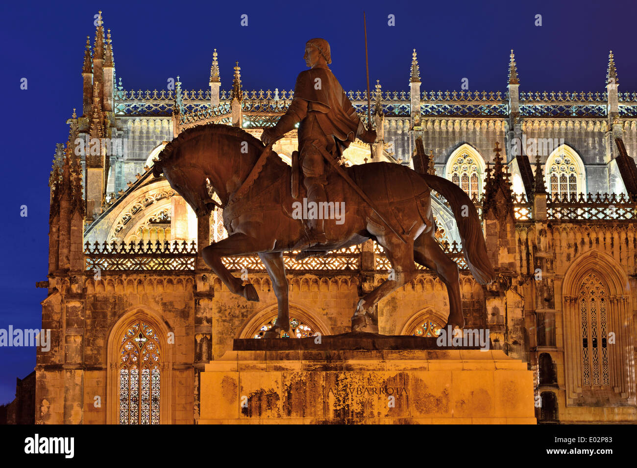 Portugal: Horse statue of Nuno Álvares Pereira and lateral view of the Monastery of Batalha by night Stock Photo