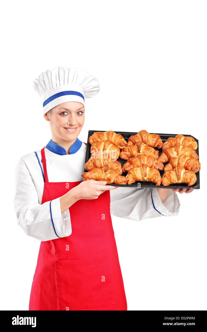 Female pastry chef holding a pan full of croissants Stock Photo