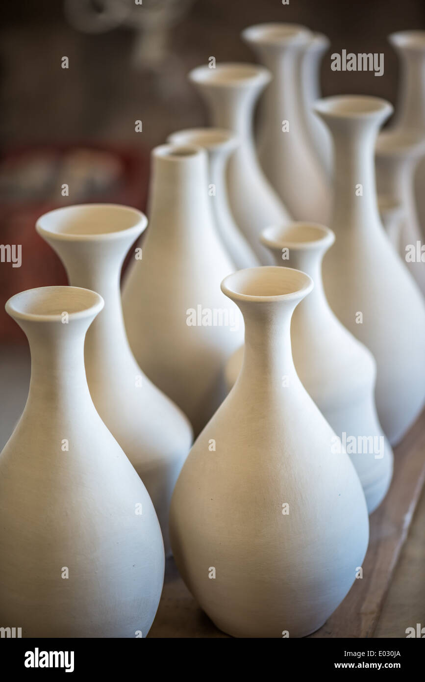 Shelve with ceramic dishware in pottery workshop Stock Photo