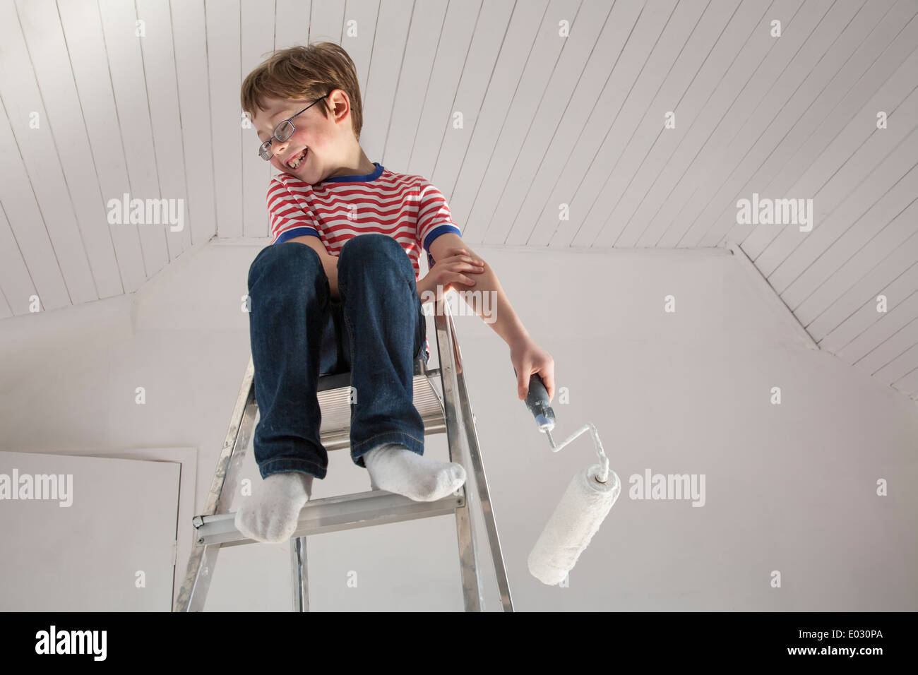 A boy seated on a stepladder. Stock Photo
