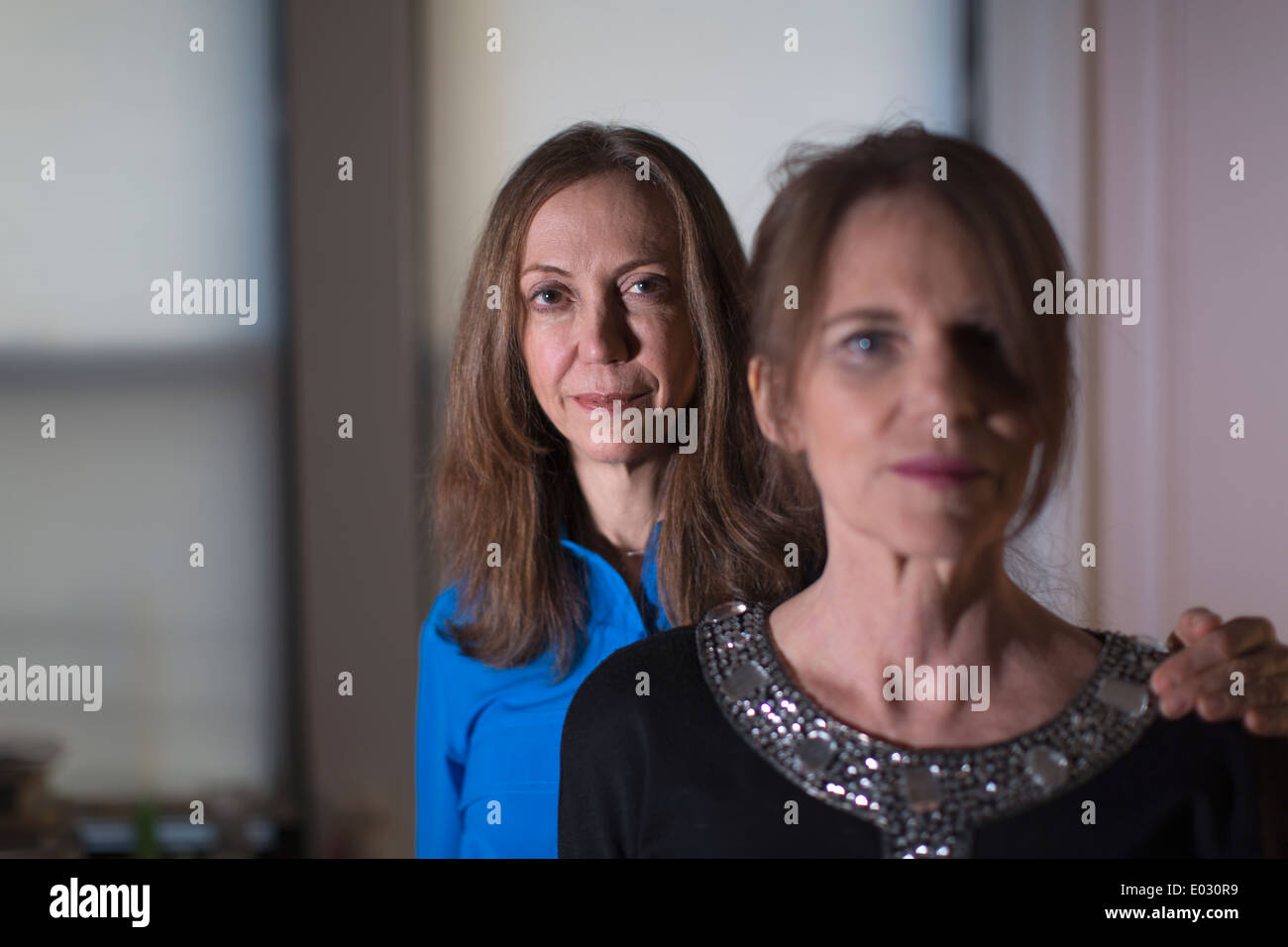 Two women standing one behind the other. Stock Photo