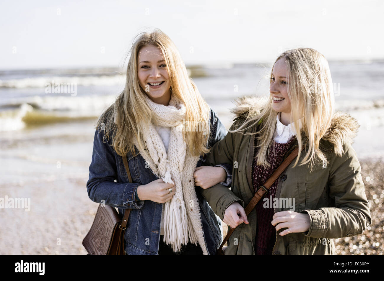 Two young girls on a beach in winter. Stock Photo