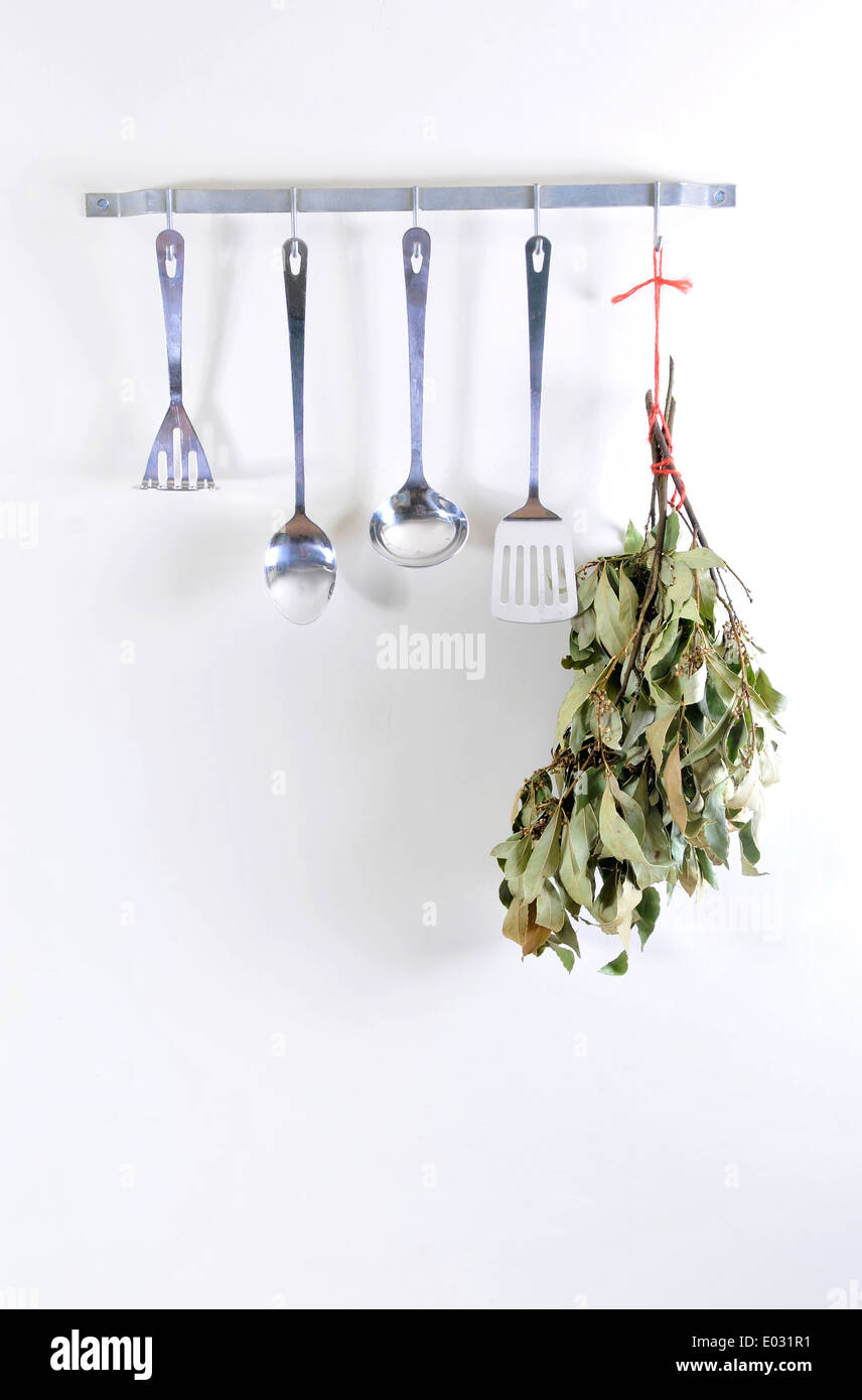Kitchen utensils hanging up with bay herbs dried Stock Photo