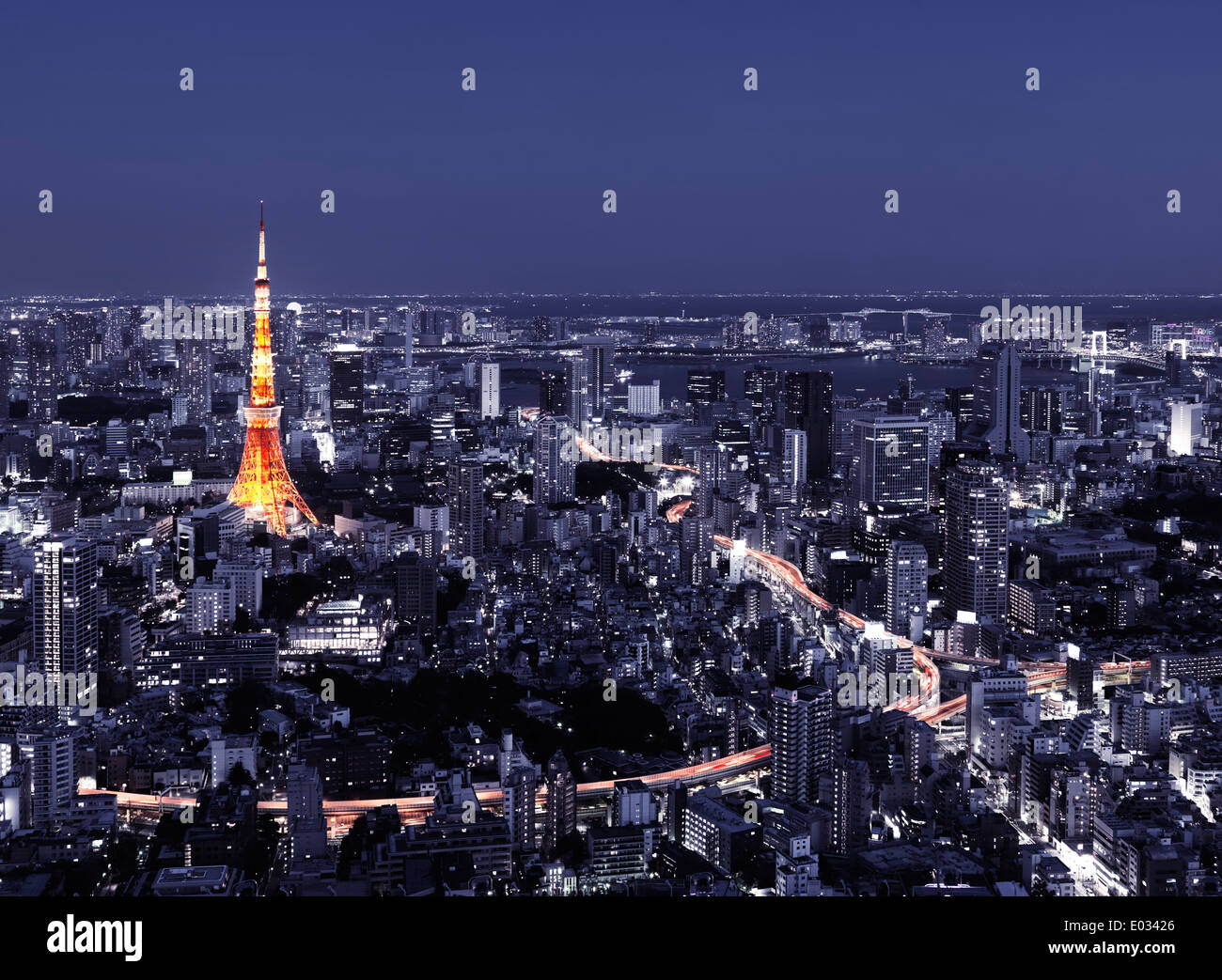 Tokyo Tower and brightly lit highways in city landscape at nighttime