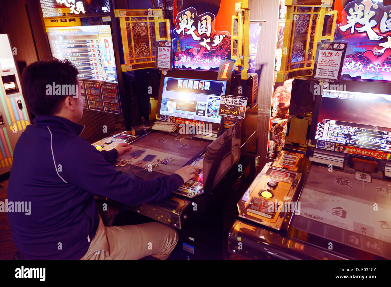 Person playing Sangokushi Taisen card game arcade slot machines in Tokyo, Japan Stock Photo