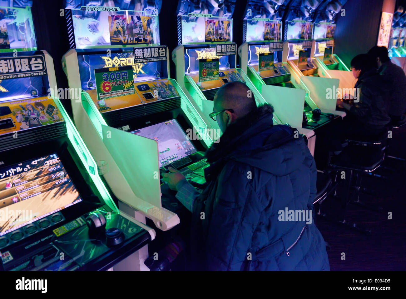 People playing Border Break video game arcade slot machines in Tokyo, Japan Stock Photo