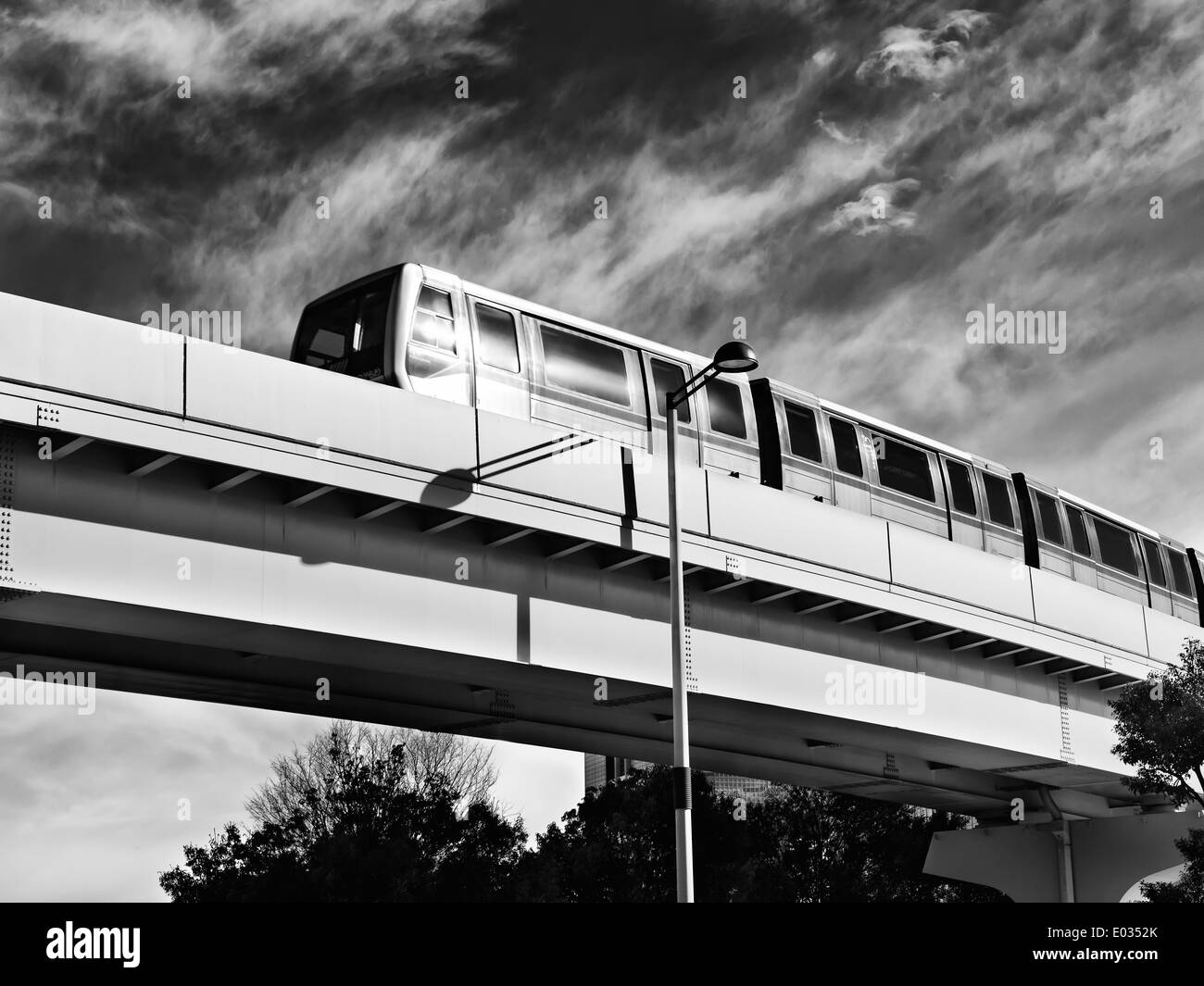 New Transit Yurikamome fully automated train going through Odaiba on elevated overhead railway in Tokyo, Japan. black and white Stock Photo