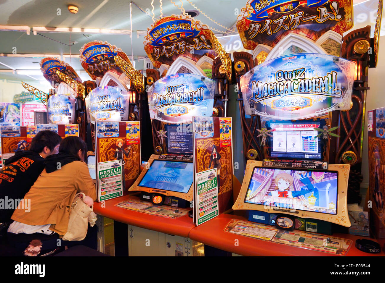 People playing Quiz Magic Academy slot machine at an arcade in Tokyo, Japan. Stock Photo