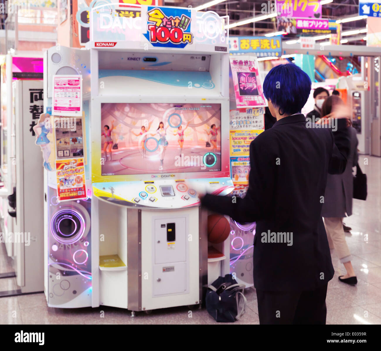 Girl playing dance station slot machine at arcade in Odaiba, Tokyo, Japan Stock Photo