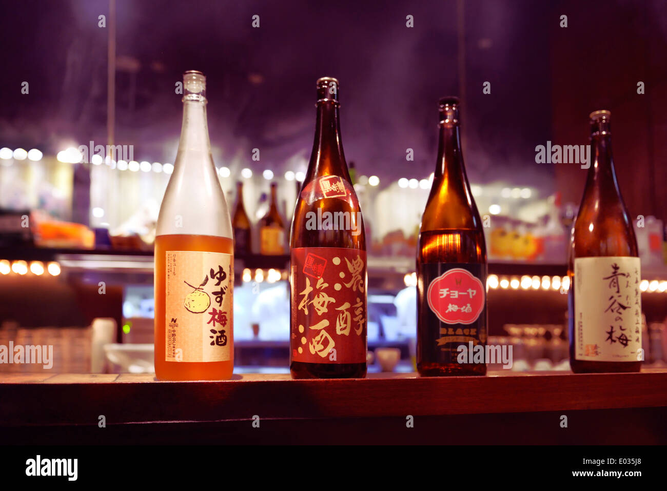 Several Japanese sake bottles, umeshu and yuzu alcoholic drinks on a bar counter. Tokyo, Japan. Stock Photo