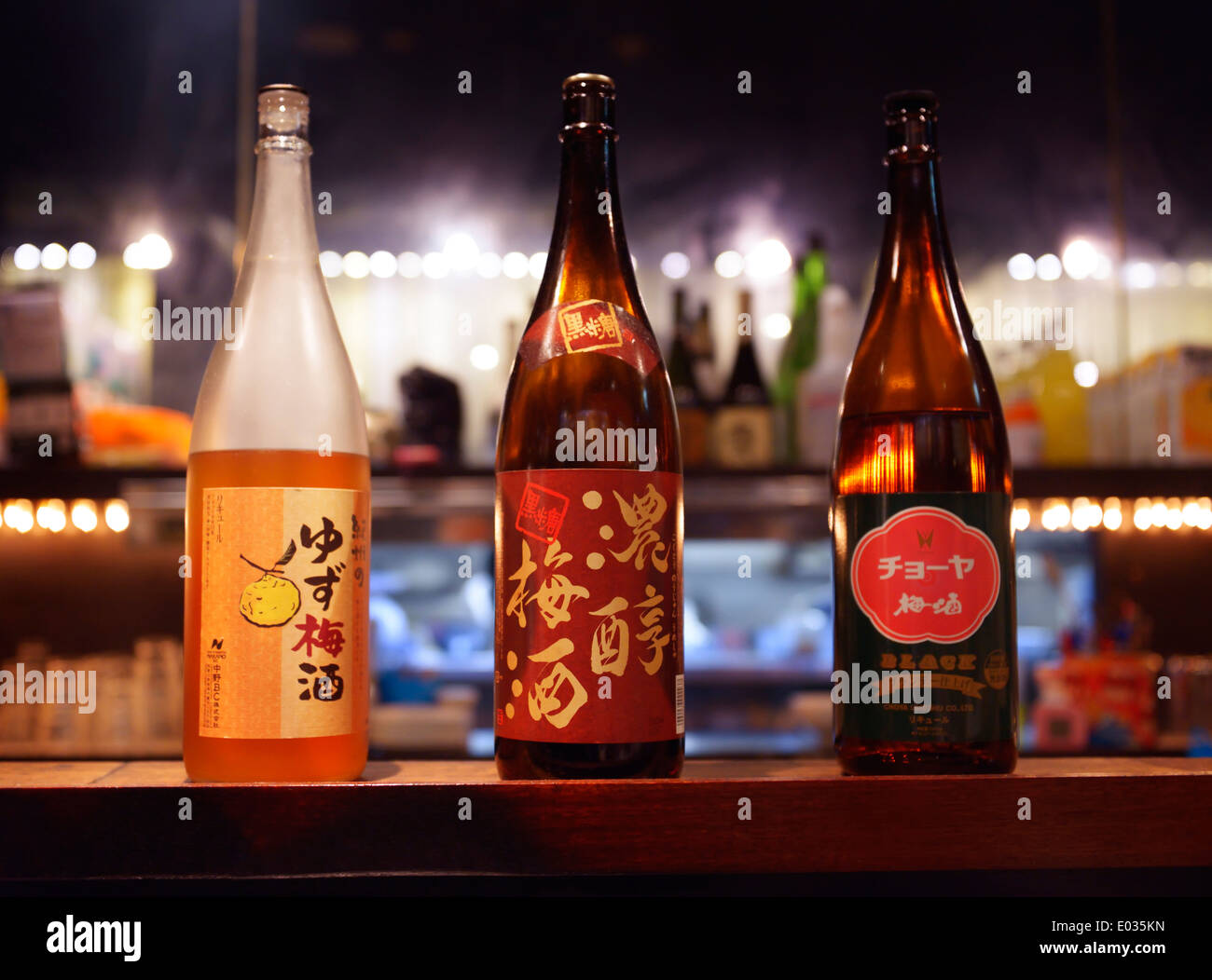 Japanese sake bottles, umeshu and yuzu alcoholic drinks on a bar counter. Izakaya. Tokyo, Japan. Stock Photo