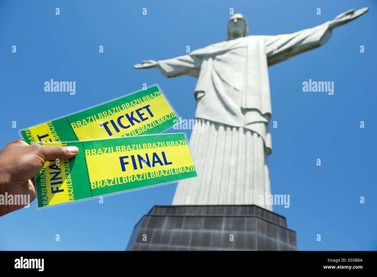 Brazilian hand holds pair of World Cup tickets up at Corcovado in Rio de Janeiro Stock Photo