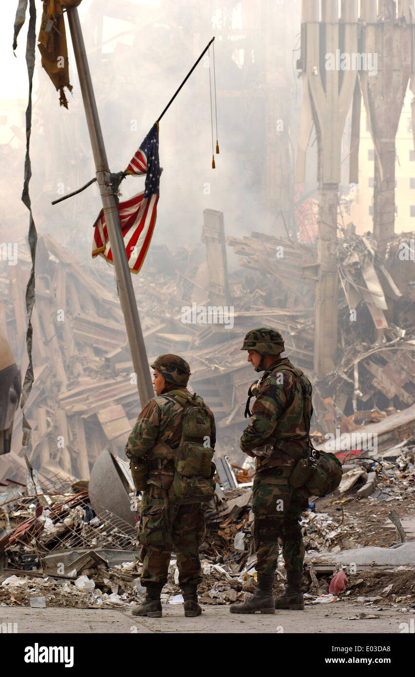Two members of the National Guard stand beneath one of hundreds of American flags amongst the wreckage of the World Trade Center in the aftermath of a massive terrorist attack which destroyed the twin towers killing 2,606 people September 19, 2001 in New York, NY. Stock Photo