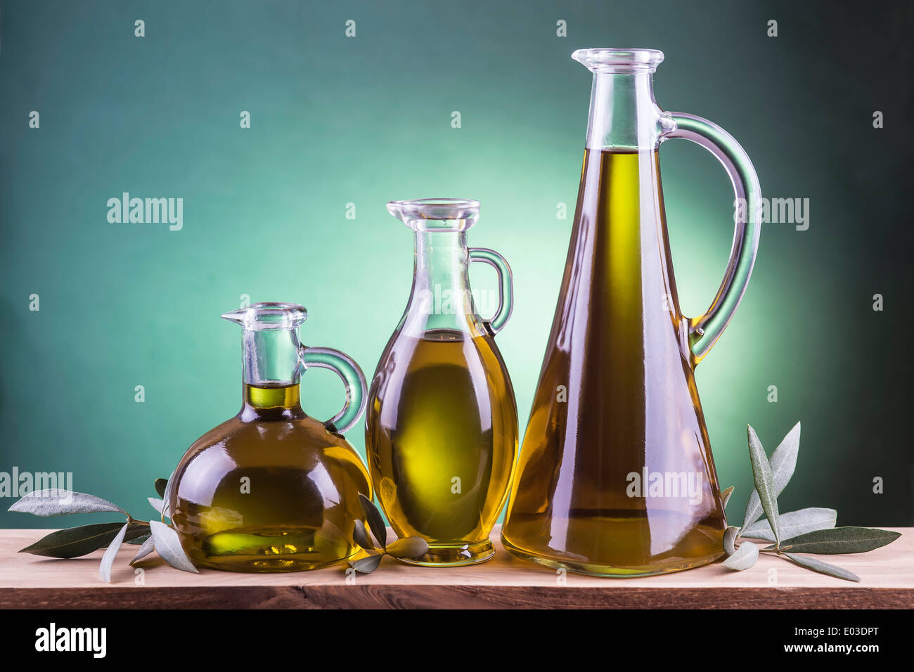 Olive oil bottles on a green spotlight background Stock Photo - Alamy