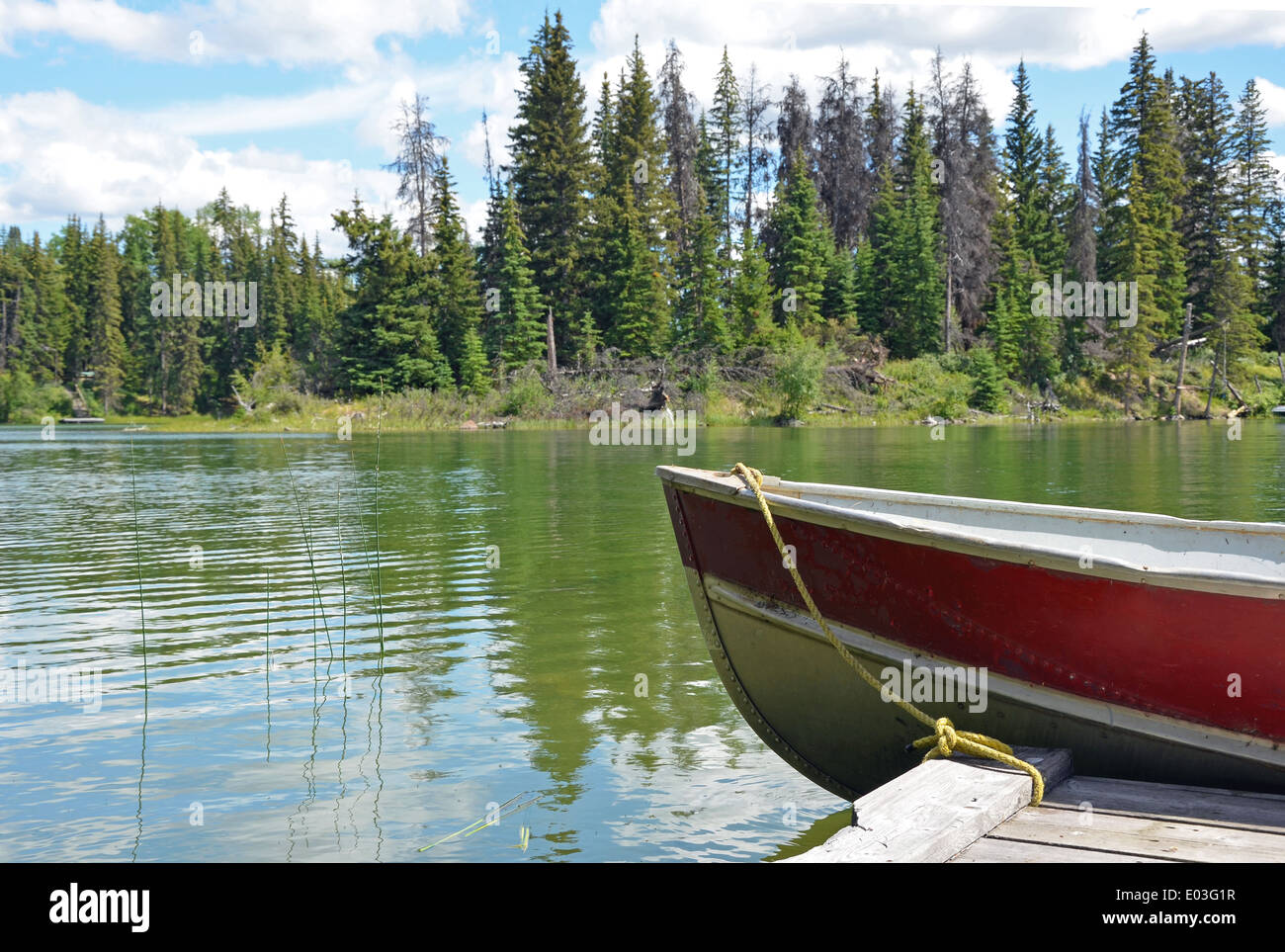 Old red boat tied to wooden dock on lake Stock Photo - Alamy