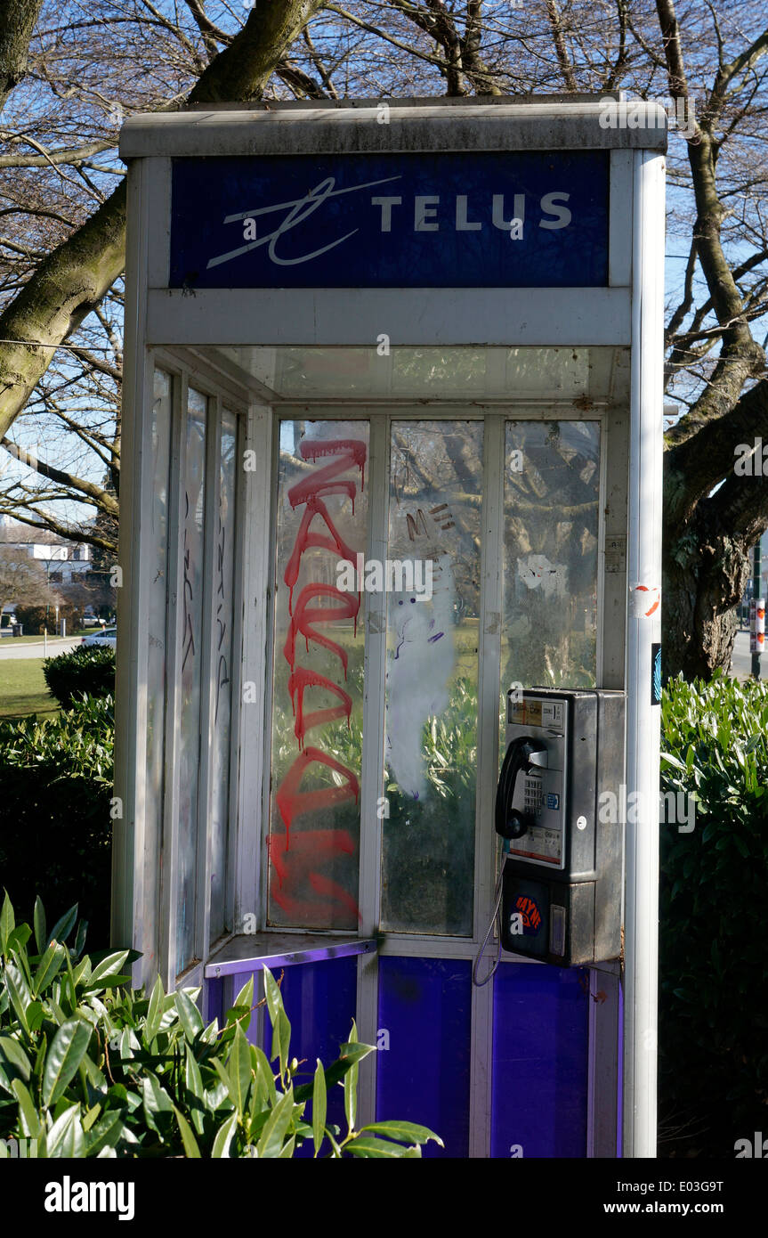 Defaced pay telephone booth in Vancouver, BC, Canada Stock Photo