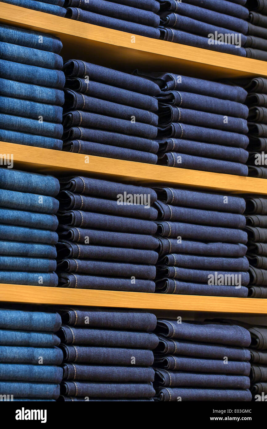 Neat stacks of folded clothing on the shop shelves Stock Photo