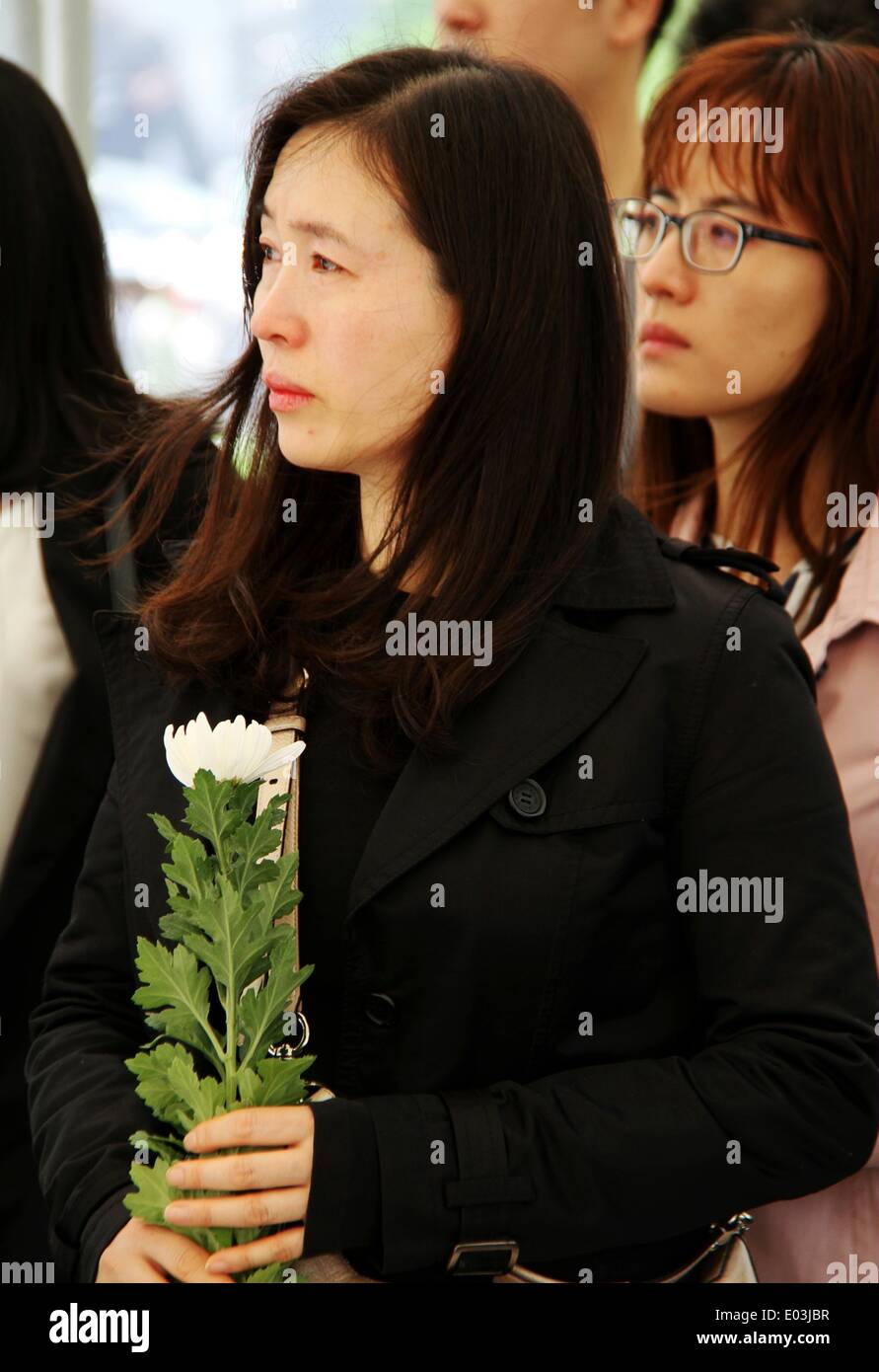 Seoul, South Korea. 1st May, 2014. A woman holding a white chrysanthemum waits to pay tribute to victims of the sunken South Korean ferry 'Sewol' at a group memorial altar in Seoul, South Korea, on May 1, 2014. © Peng Qian/Xinhua/Alamy Live News Stock Photo