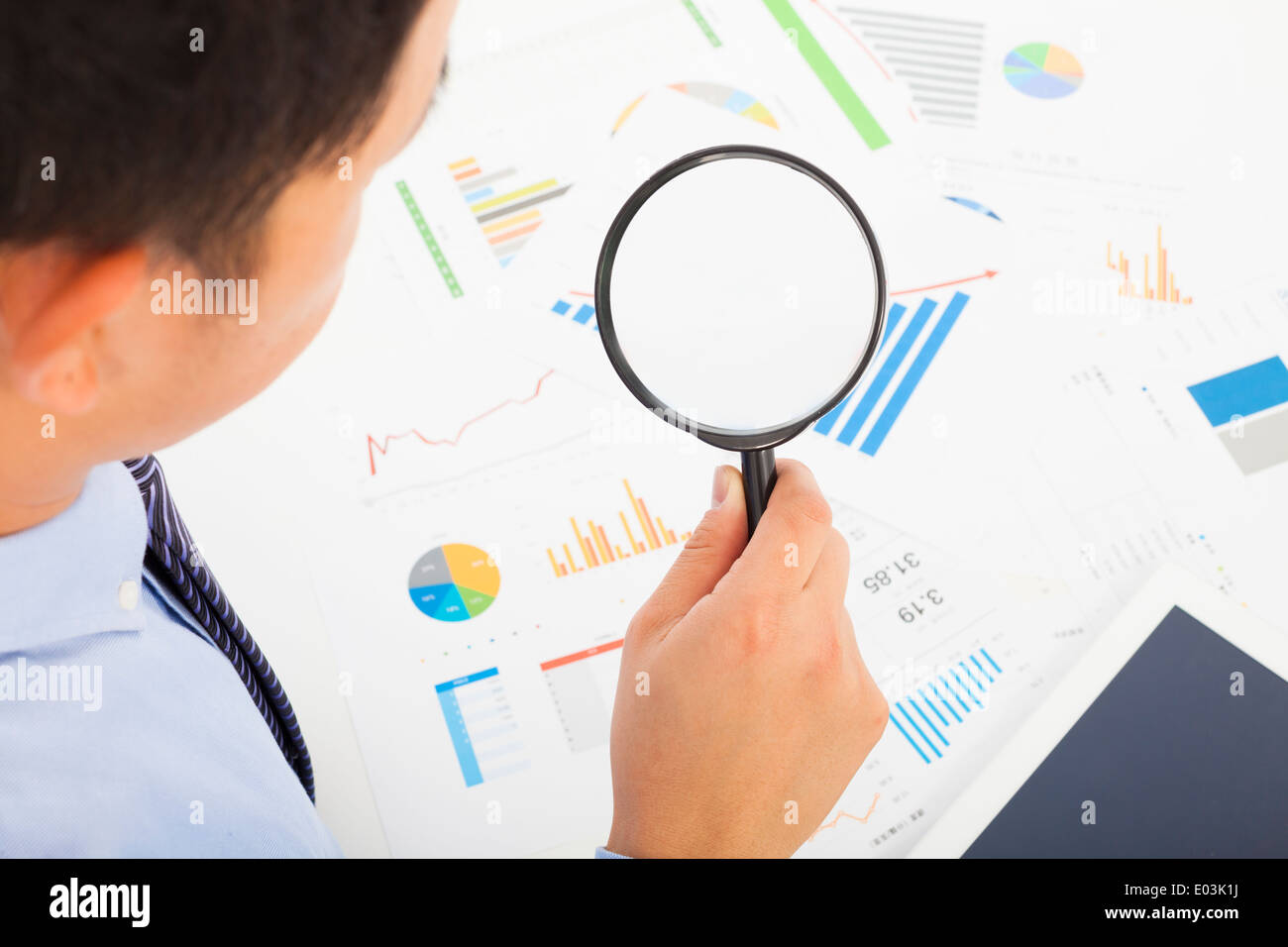 Businessman looking through magnifier glass to documents Stock Photo