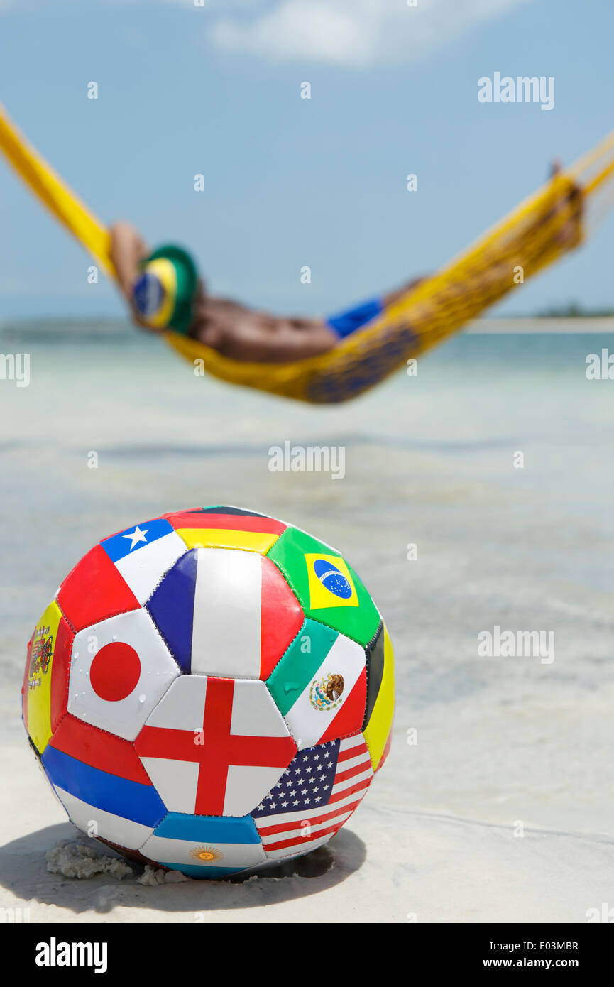 Brazilian man relaxing in beach hammock with international team flag