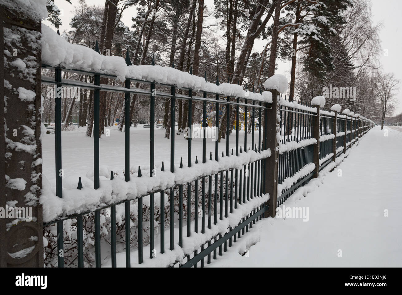 Snow in the city park. A snowy fence Stock Photo - Alamy