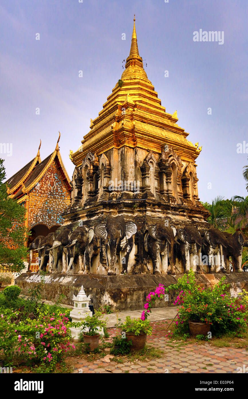 Gold spire of the chedi decorated with elephants in Wat Chiang Man Temple in Chiang Mai, Thailand Stock Photo