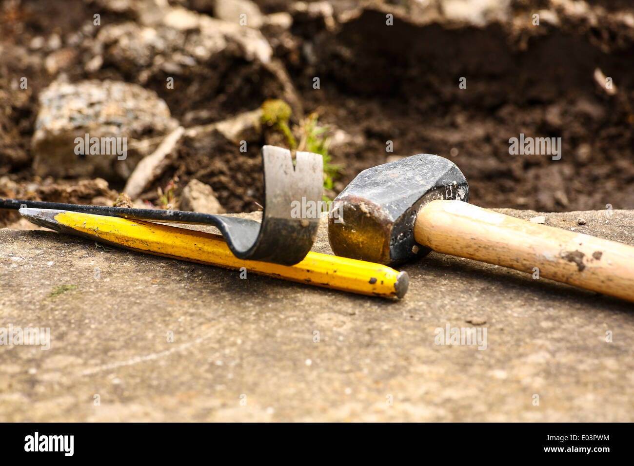 Bolster hammer, chisel and crowbar placed on flagstone during path