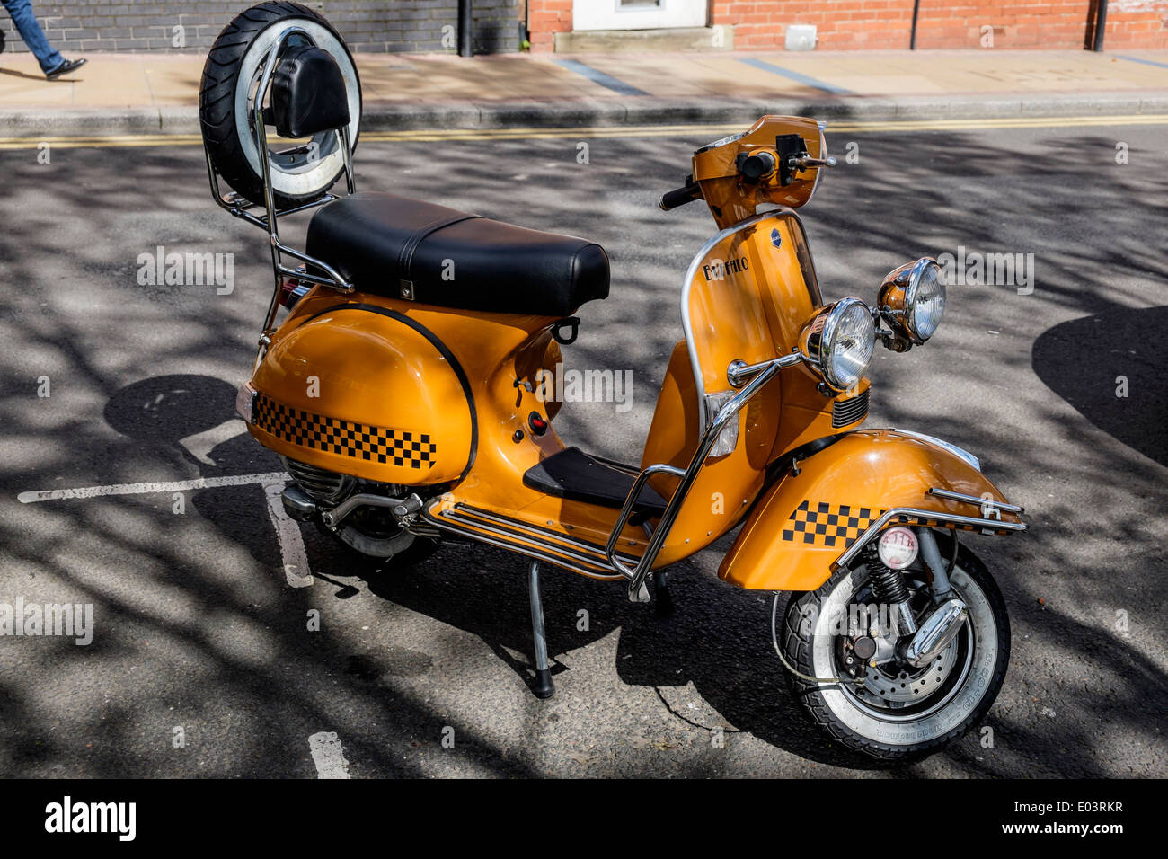 Orange scooter parked on  roadside  England Stock Photo